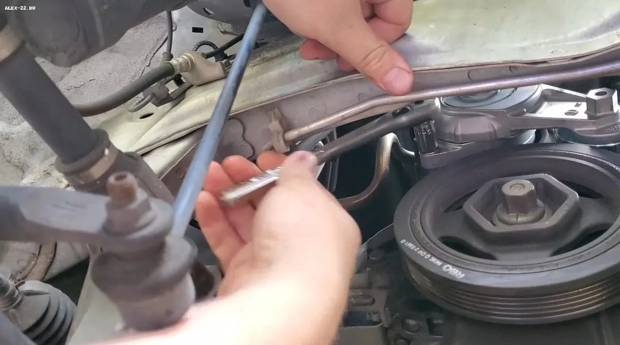 honda jazz unscrew the down tensioner bolt, откручиваем нижний болт натяжителя ремня